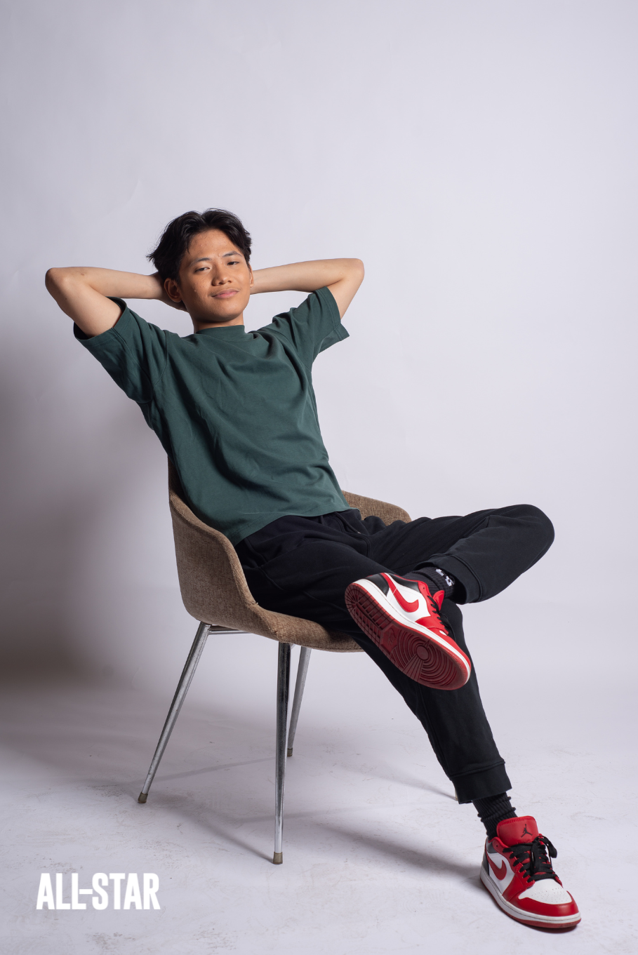 Filipino boy wearing shirt while sitting on a chair, relaxed pose