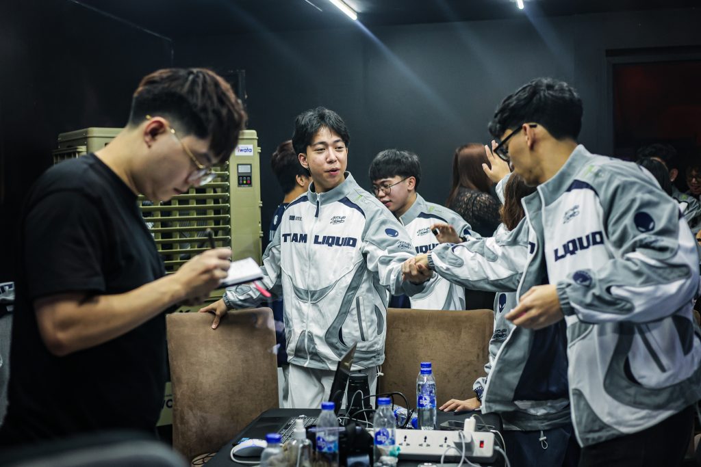 Coach Aeon scribbles crucial plans on his notebook while the team celebrates a game win. Photo by Richard Dizon Esguerra | MPL Philippines. 